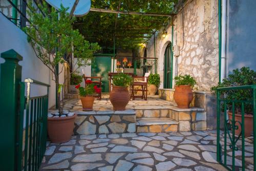 an outdoor patio with potted plants and tables and chairs at Filippa's Katoi in Drymon