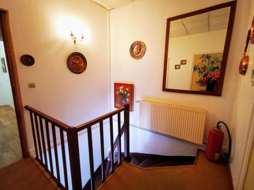 a hallway with a staircase with a mirror and a mirror at Le Coin des Artistes in Giverny