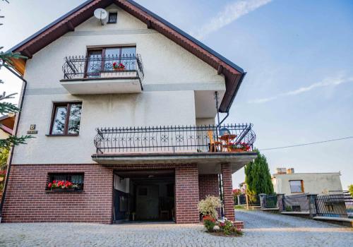 a building with two balconies on the side of it at Mira - Mira pokoje z widokiem na jezioro in Chmielno