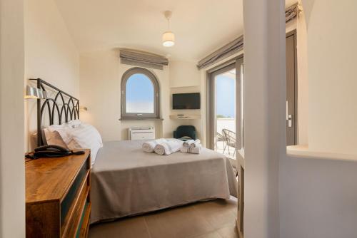 a bedroom with a bed with towels on it at Insula Boutique Hotel in Procida