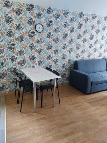 een woonkamer met een tafel en een bank bij Apartamentai „Kaip namuose“ in Druskininkai