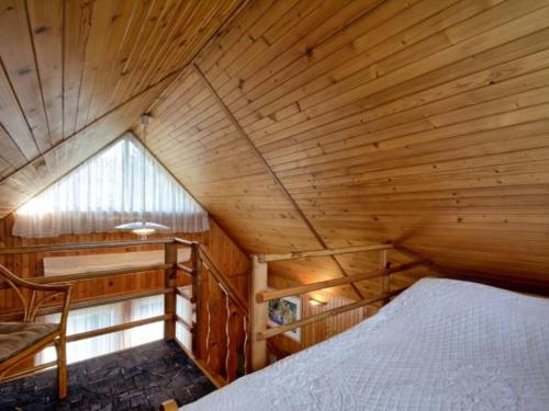 - une chambre avec un lit dans une pièce en bois dans l'établissement Blisko morza, à Jastarnia