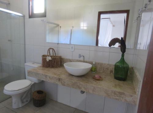 Un baño con lavabo, inodoro y espejo. en Concept House Caraiva, en Caraíva