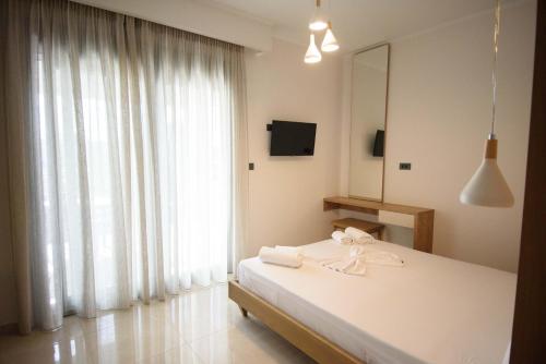 a bedroom with a bed and a large window at Villa Ikaros in Ammoudia