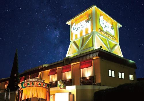 a building with a sign on top of it at night at プレゼントホテル チャペルガーデン 可児 ｰ大人専用ｰ in Kani