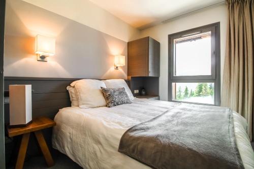 a bedroom with a large bed and a window at South-facing newly renovated 2-bed apartment Les Terrasses d'Eos in Flaine