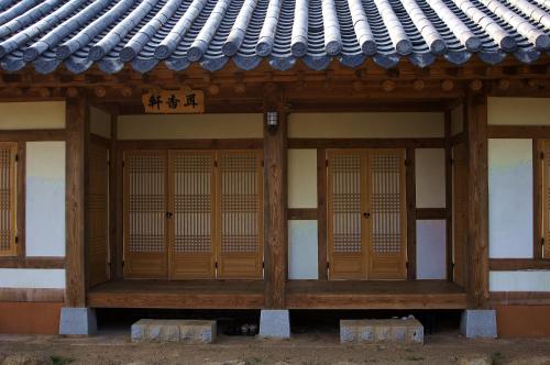 a building with wooden doors and a roof at Korean Traditional House - Chungnokdang in Boseong