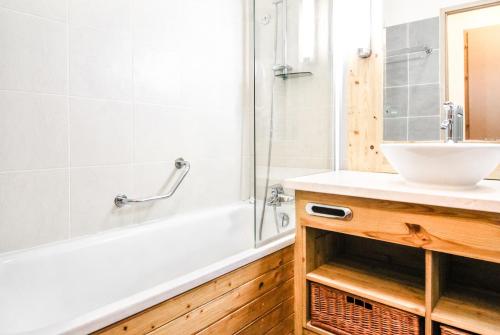 une salle de bain avec un lavabo et une baignoire dans l'établissement Beautiful one-bedroom apartment with fireplace and stunning views, à Flaine