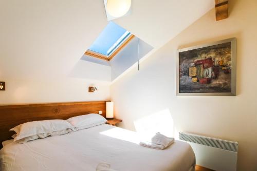 une chambre avec un lit et une lucarne dans l'établissement Beautiful one-bedroom apartment with fireplace and stunning views, à Flaine