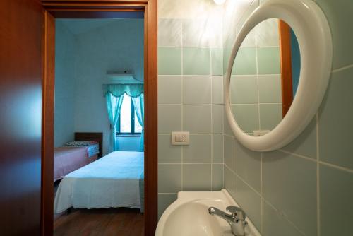 La salle de bains est pourvue d'un lavabo, d'un miroir et d'un lit. dans l'établissement Dimora Terrazza sui Calanchi, à Atri