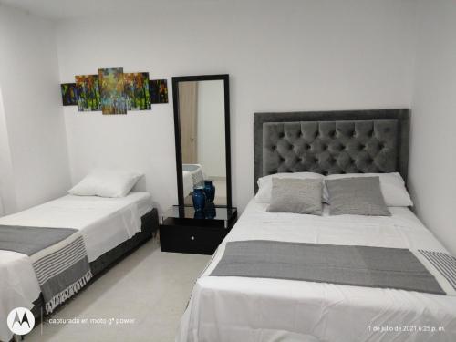 - une chambre avec 2 lits et un miroir dans l'établissement Hermoso Apartamento Amoblado, à Carthagène des Indes