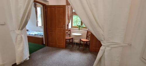 a room with a door and a table and a window at Horské ubytování Královský dvůr na Bílém potoce in Hamry