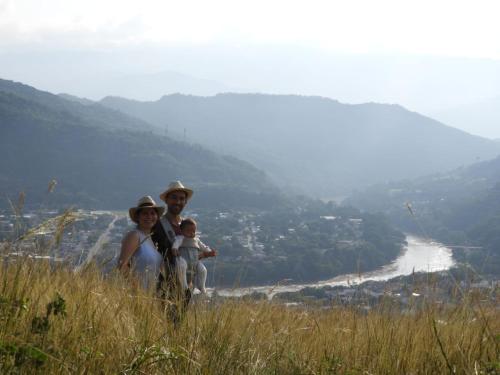 a man and woman standing on a hill with a baby at Waka Hotel Rural in Honda