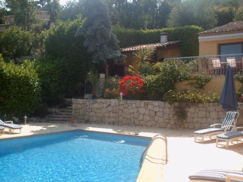 una piscina en un patio con sillas y una casa en Maison d'hôtes Escale d'Azur, en Gattières