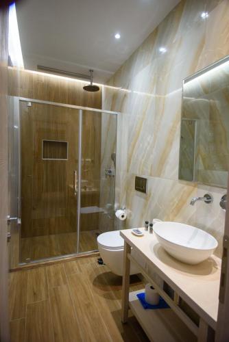 a bathroom with a toilet and a sink and a shower at Villa Ikaros in Ammoudia