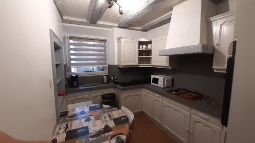 - une cuisine avec des placards blancs et une boîte au sol dans l'établissement Apartment Corneille, à Colmar