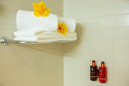 a pile of towels on a shelf in a bathroom at MS Vila Nova in Ponta Delgada