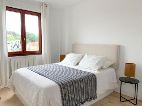 Ένα ή περισσότερα κρεβάτια σε δωμάτιο στο ACOGEDOR APARTAMENTO CON TERRAZA Y PARKING Publico EN COMILLAS