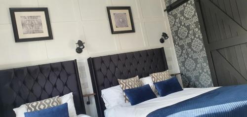 a bedroom with a bed with two blue pillows at The Clifton in South Shields