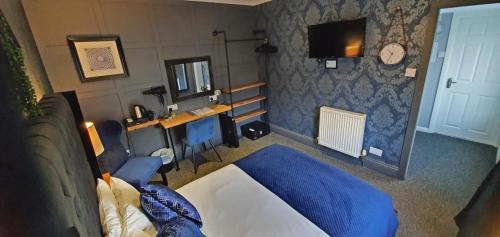 a bedroom with a bed and a desk and a television at The Clifton in South Shields