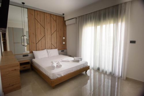 a bedroom with a bed and a large window at Villa Ikaros in Ammoudia