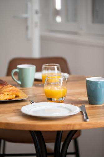 une table en bois avec une plaque et un verre de jus d'orange dans l'établissement CUDJOE, à Dinan