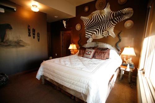 a bedroom with a bed with a zebra headboard at Swan River Inn in Bigfork
