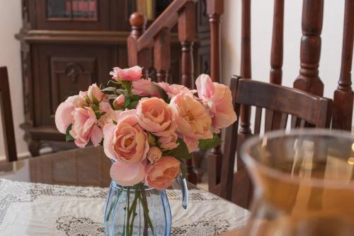 a vase filled with pink roses on a table at Filippa's Katoi in Drymon