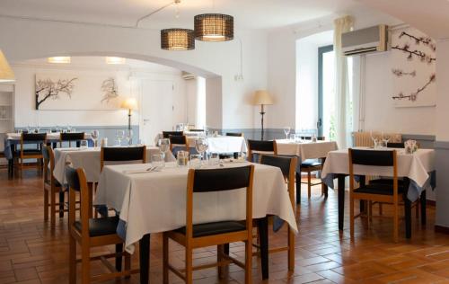 a restaurant with tables and chairs with white tablecloths at Hostal la Salut de Terrades in Terrades