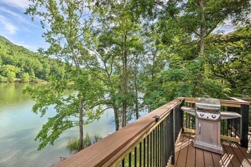 a deck with a grill next to a body of water at Cozy Cabin on Tenn River - 10 Mi to Chattanooga! in Chattanooga