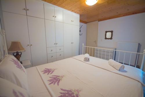 a bedroom with a white bed with a wooden ceiling at Filippa's Katoi in Drymon