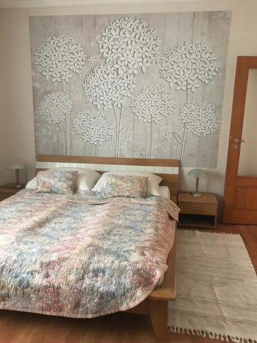 a bedroom with a bed and a wall with dandelions at Bartalos ház in Zánka
