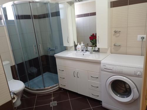 a bathroom with a shower and a washing machine at Villa Nefeli Ksamil in Ksamil