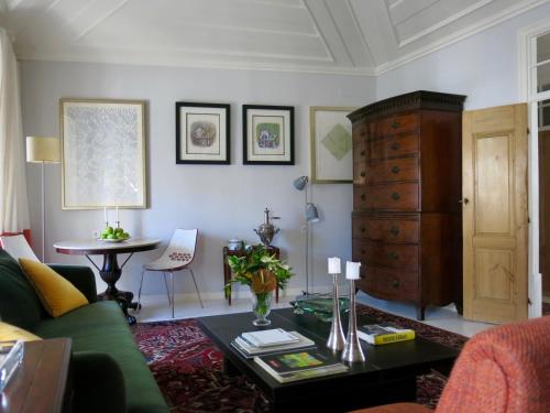 a living room with a green couch and a table at São Paulo Boutique Hotel - SPBH in Tavira