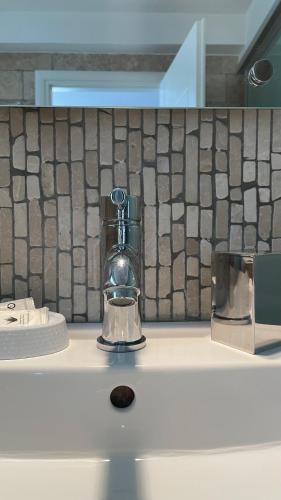 a bathroom sink with a soap dispenser on a counter at Coquille in Kavála
