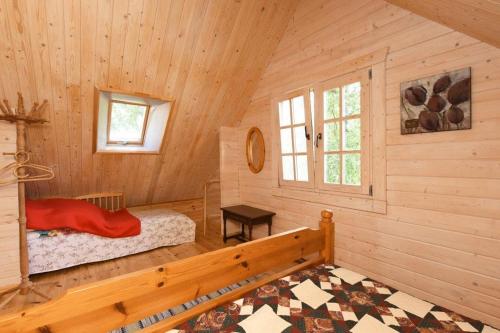 a log cabin with a bed and a window at Judbidzi in Pape