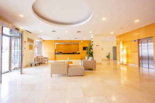 a lobby with a couch and chairs in a building at MS Vila Nova in Ponta Delgada