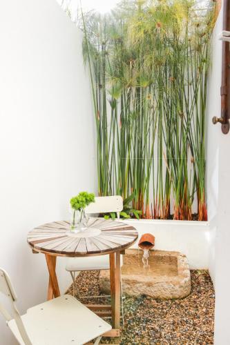 a room with a table and chairs and plants at São Paulo Boutique Hotel - SPBH in Tavira