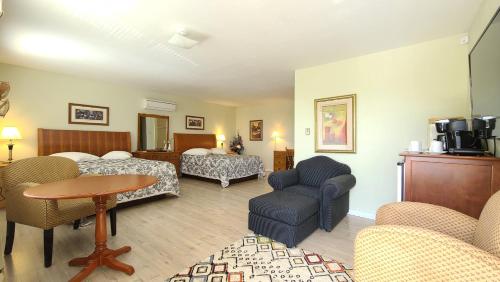a hotel room with a bed and a couch and a table at Bouctouche Bay Inn in Bouctouche