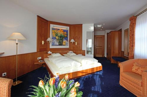 a bedroom with a large bed and a couch at Hotel-Restaurant Adler in Lahr