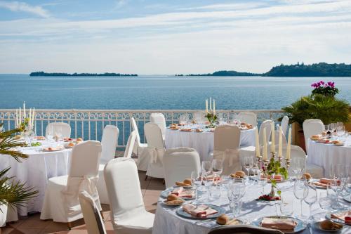 a table set up for a wedding with a view of the water at Grand Hotel Gardone in Gardone Riviera