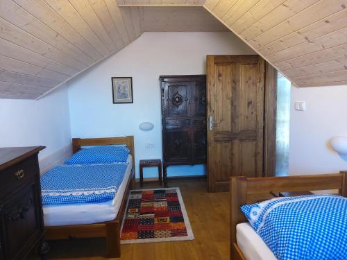 sypialnia z 2 łóżkami i drewnianym sufitem w obiekcie Vinařský dvůr Šakvice w mieście Šakvice