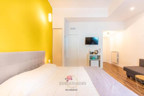 a bedroom with a large bed with a yellow wall at Duchessa Ravaschieri bed and breakfast in Naples