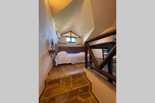 a attic room with a bed and a window at SENTOYKI VILLAGE HOME - ΜΟΝΟΚΑΤΟΙΚΙΑ ΣΕ ΘΑΛΑΣΣΑ in Melission