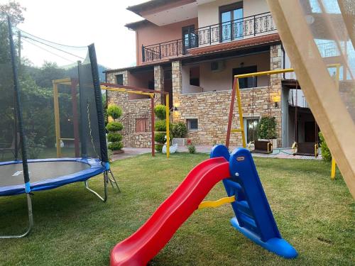 a playground in front of a house with a slide at Studios Anna Paradise in Skala Potamias