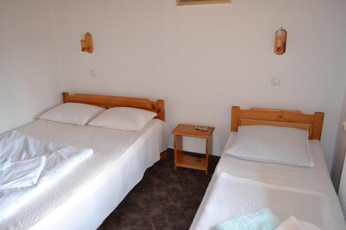 a room with two beds and a night stand at Pensiunea Muntean in Sibiel