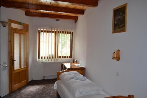 Un pat sau paturi într-o cameră la Pensiunea Muntean