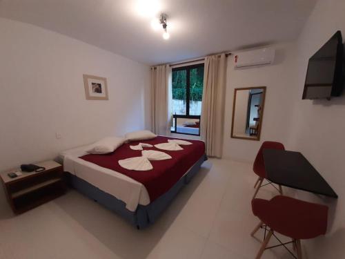 1 dormitorio con 1 cama y TV en Suite Real Residencial, en Río de Janeiro