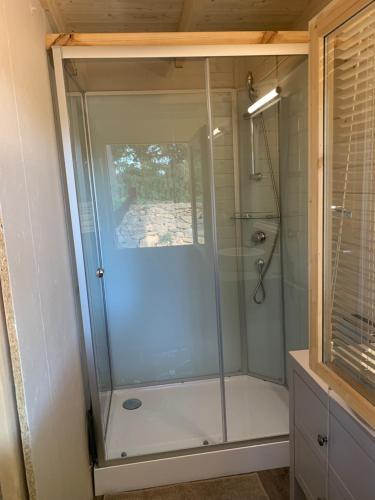 a shower with a glass door in a bathroom at Chambre privée avec accès piscine in Laouque