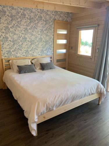 a bedroom with a large white bed with a window at Chambre privée avec accès piscine in Laouque